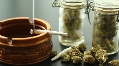 stock-footage-marijuana-joint-burning-a-marijuana-filled-joint-burning-on-the-edge-of-a-wooden-ashtray-jars